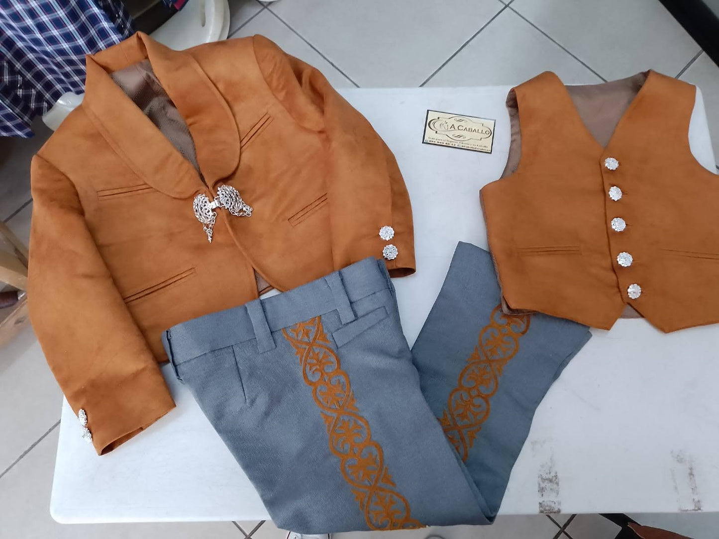Traje Charro 3 Piezas, Chaleco y Chaquetila en Gamuzina, Pantalon en tela casimir, con greca al tono de chaquetilla, Herraje en baño de plata en chaquetilla.